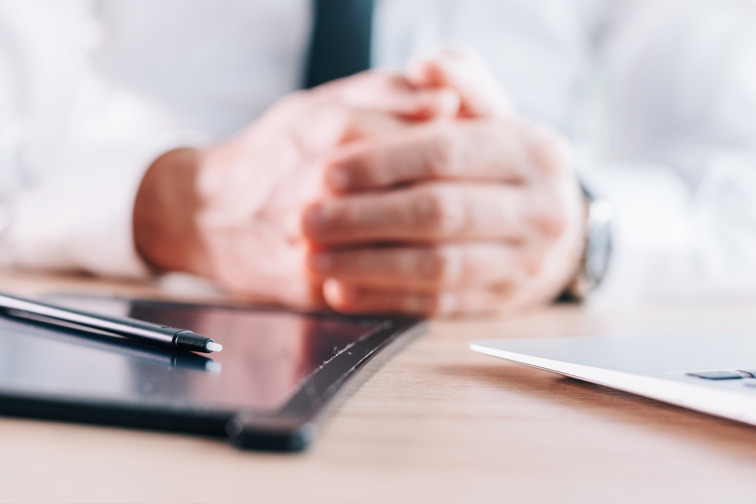 Photo of somebody's hands resting on desk